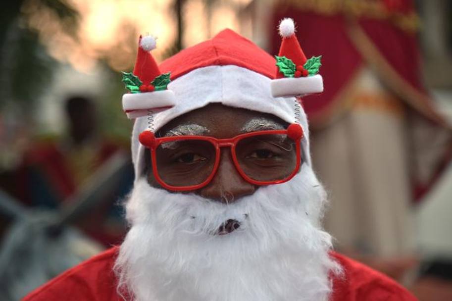 Haiti, un uomo vestito da Babbo Natale partecipa ad una sfilata natalizia, AFP 